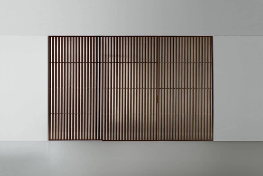 Rimadesio Sail schuifdeur met verticale houten lamellen toegepast als architectonische roomdivider