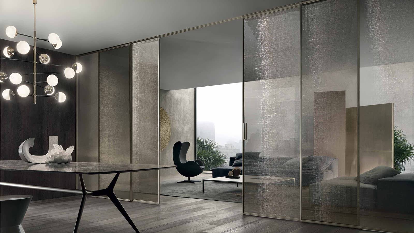 Rimadesio Velaria schuifdeur in rete bronzo glas met aluminium profiel, toegepast als transparante afscheiding in een luxe inloopkast