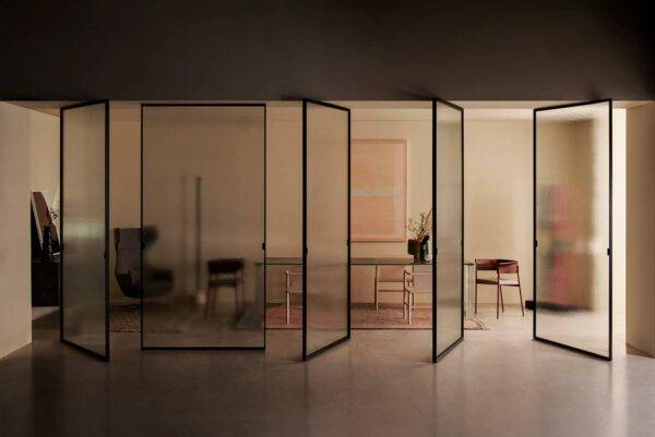 design glazen taatsdeuren of pivot deur met een zwart aluminium kader en bewerkt glas