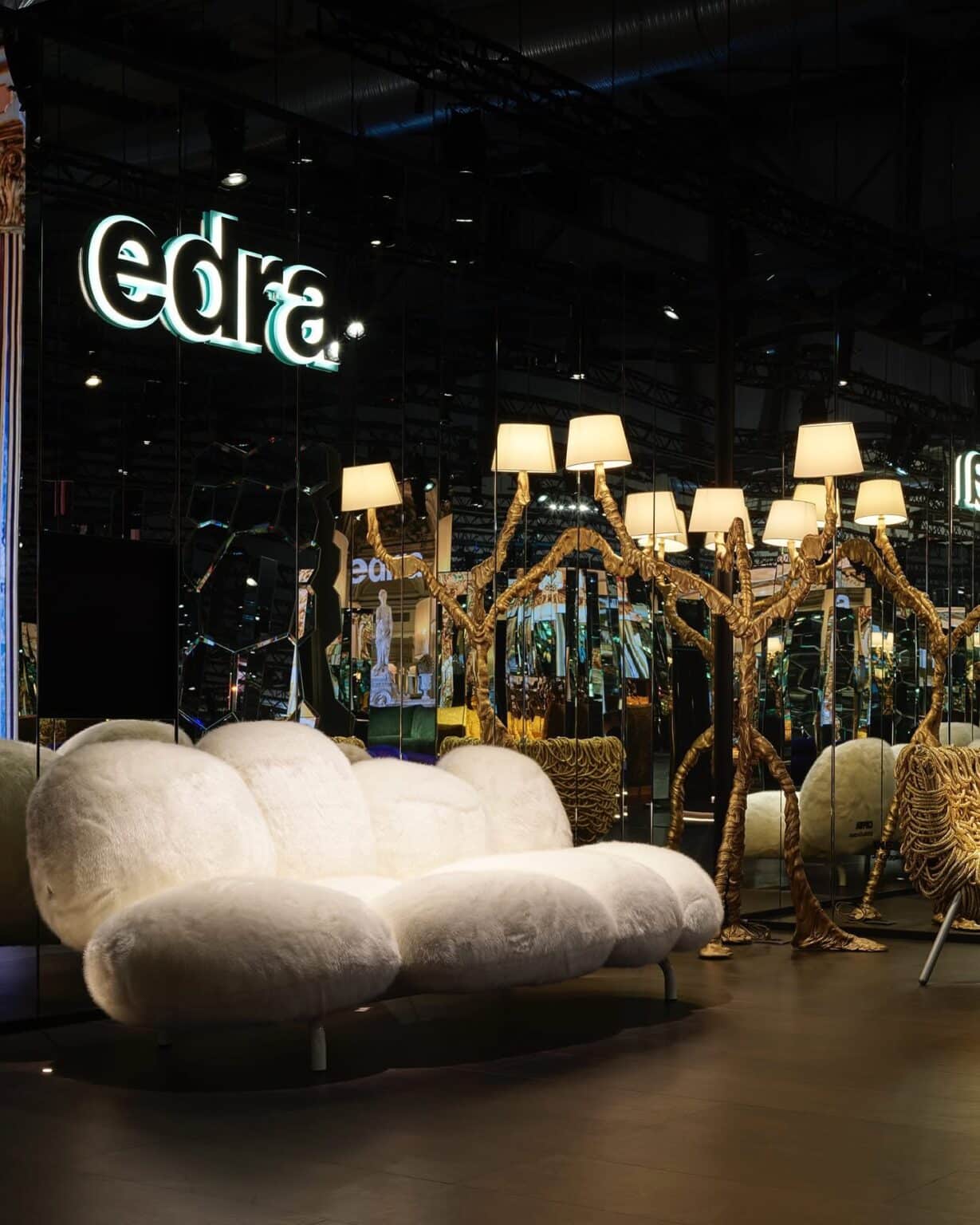 Witte fluffy sofa van Edra gepresenteerd op Salone del Mobile 2025 – weelderig design met organische vormen, omringd door gouden boomvormige lampen in spiegelpaleis.