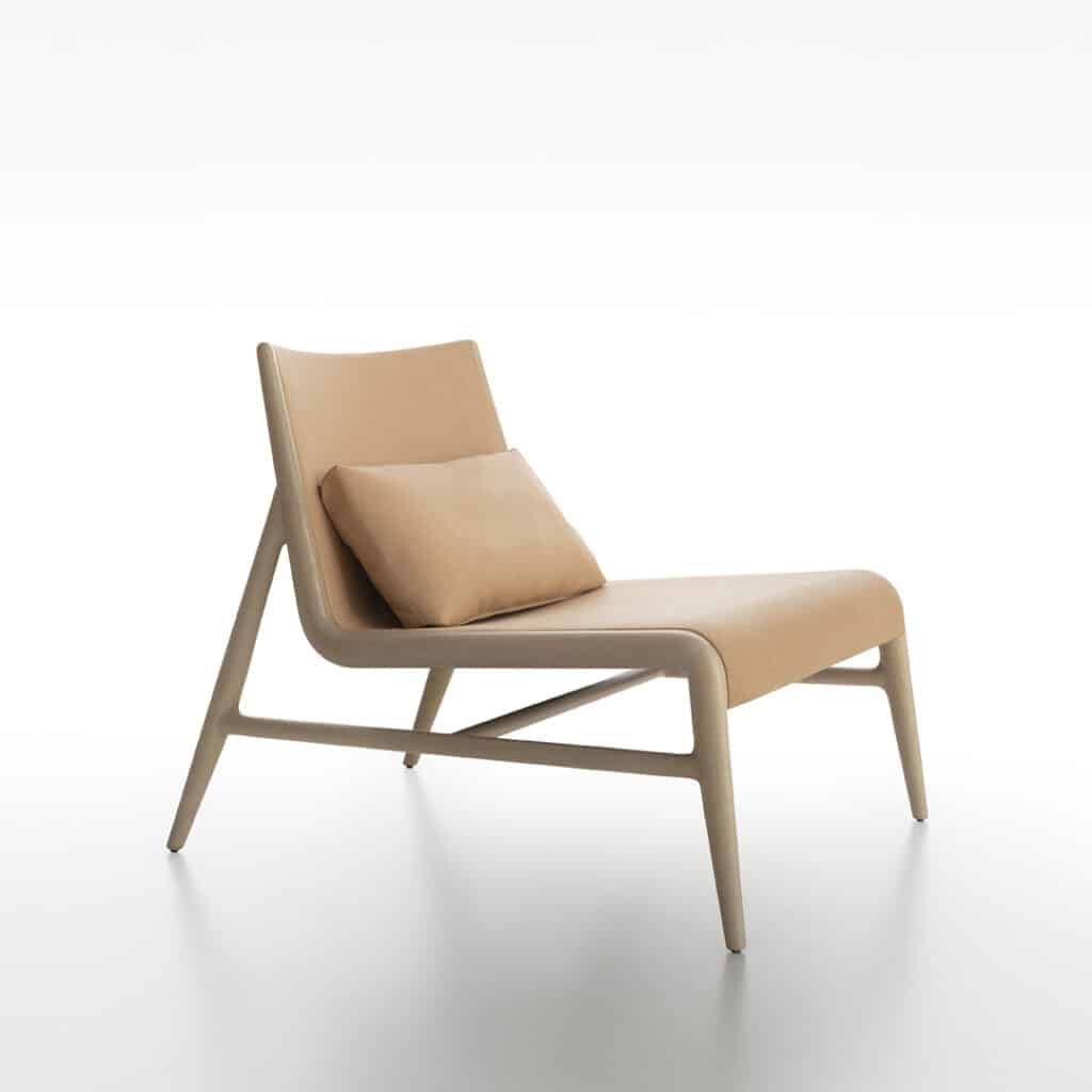 Rimadesio Sinua-loungechair in naturel leer, met een zachte, lage belijning en verfijnd houten frame, waarin comfort en elegantie samenvloeien tot een sculpturaal object in een puur, licht omhulsel.