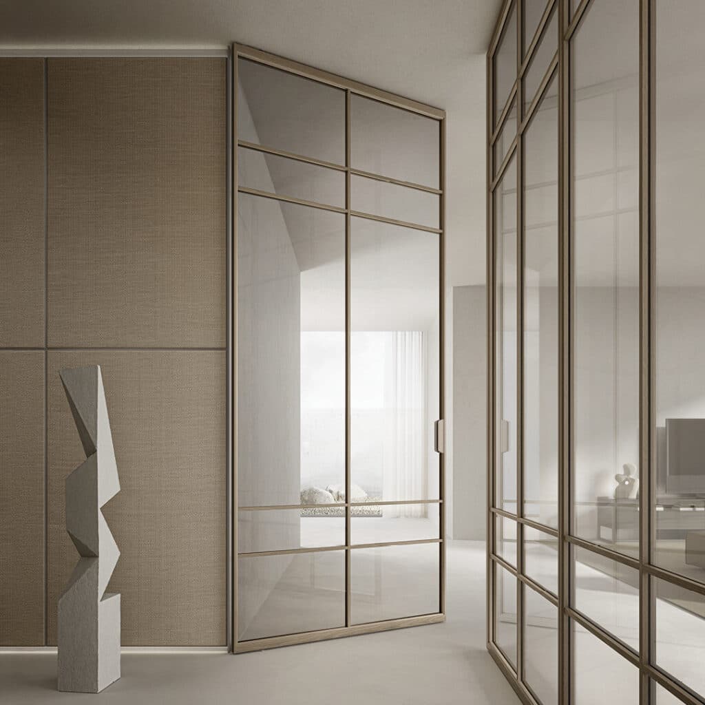 Rimadesio Air pivotdeur met symmetrisch glazen rasterpatroon in een aluminium frame, geïntegreerd in een modern interieur