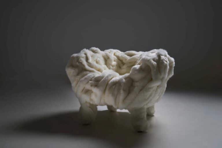 Edra Grinza White fauteuil in studio-opname met zachte bekleding en uitgesproken plooivorming, belicht met schaduwwerking