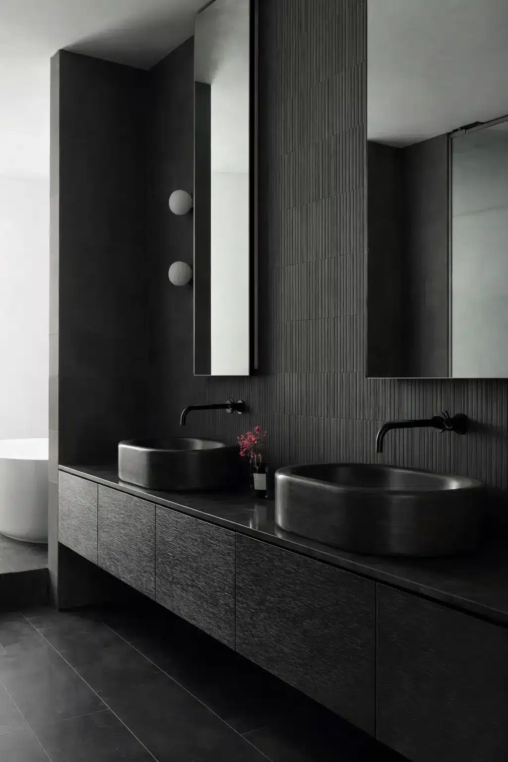 Maatwerk badkamer in luxe villa met donkere natuursteen wastafels en geïntegreerde verlichting, ontworpen door Noctum Interieurstudio