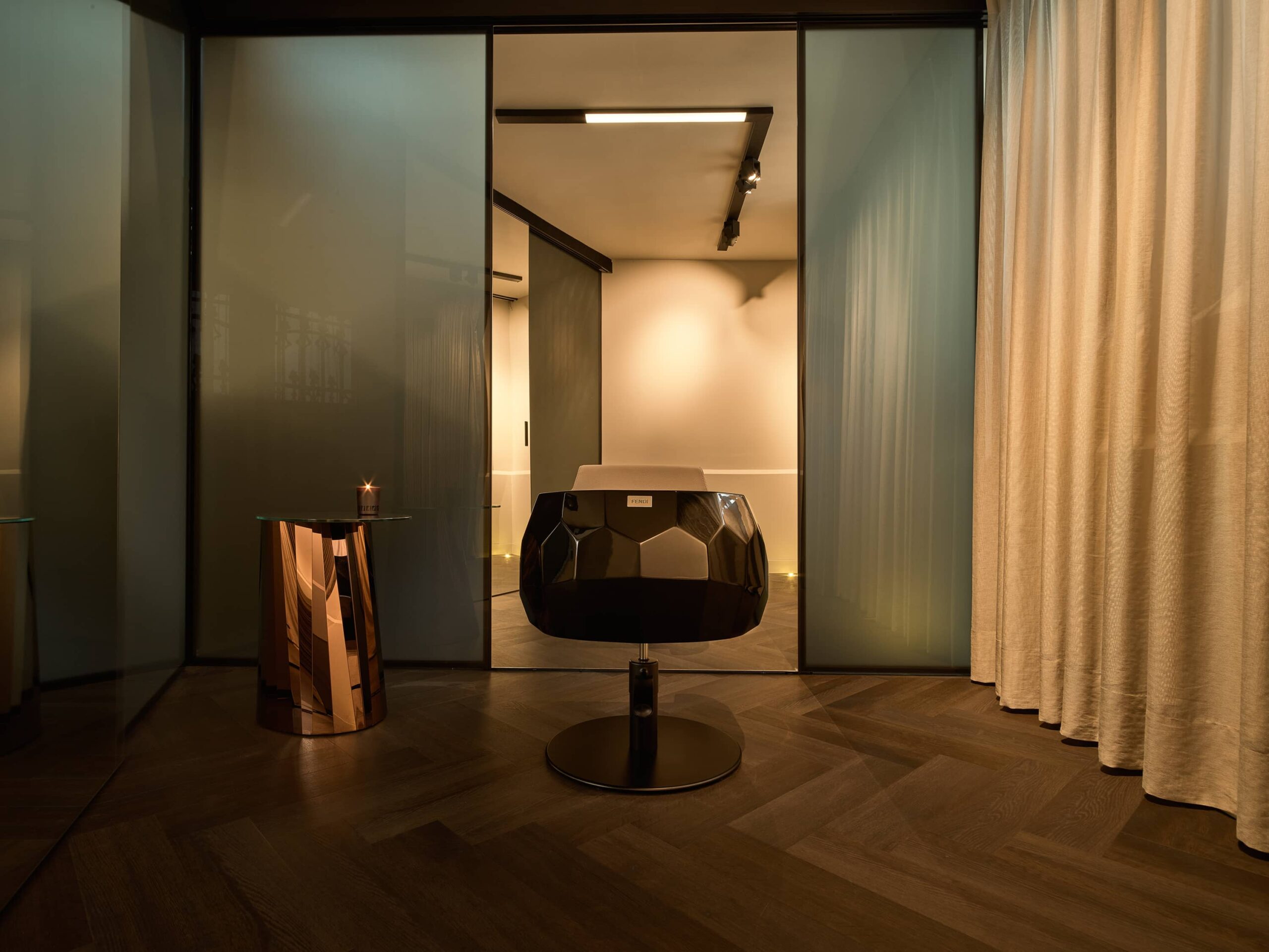 Detail van de private suite met fauteuil en glazen wand binnen het Conservatorium Hotel Amsterdam.