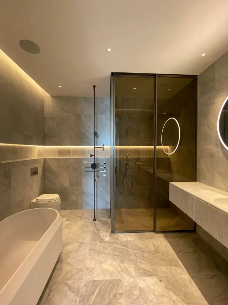 Agape vrijstaand bad met Salvatori natuursteen wandtegels en Rimadesio glazen douchewand in luxe badkamer met geïntegreerde verlichting
