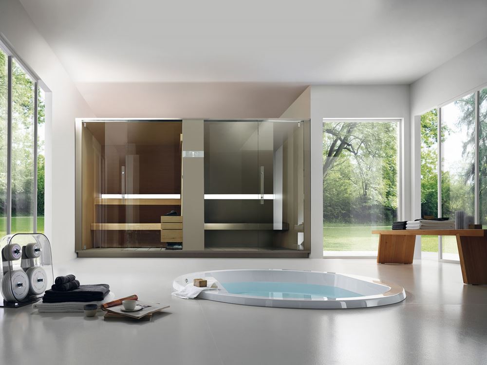 EFFE sauna en hammam combinatie in glas geïntegreerd in een wellnessruimte met bad en zicht op de tuin