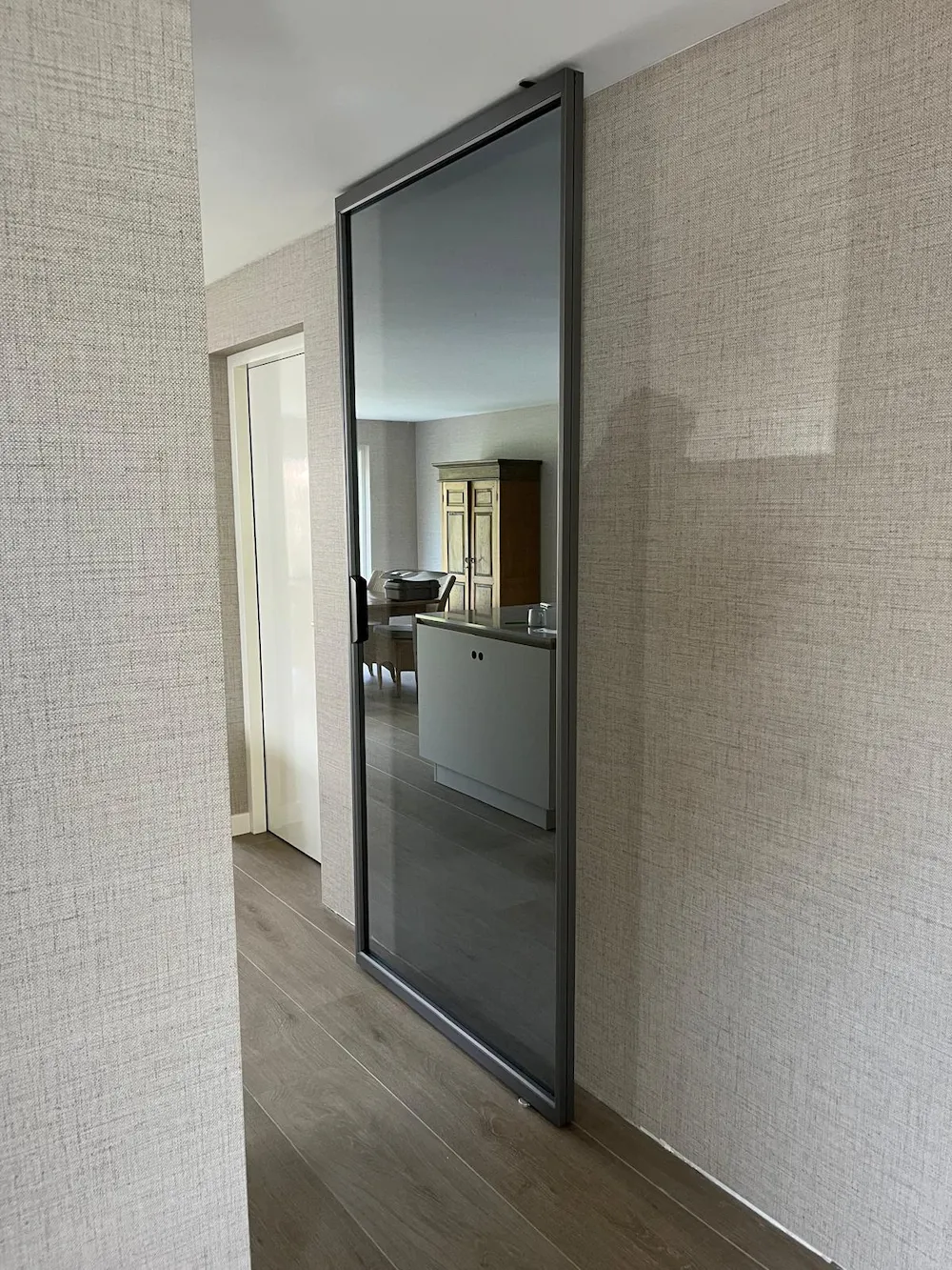 Rimadesio Air Pure taatsdeur toegepast in entree van woning, geïntegreerd in wandopbouw, gerealiseerd door Noctum