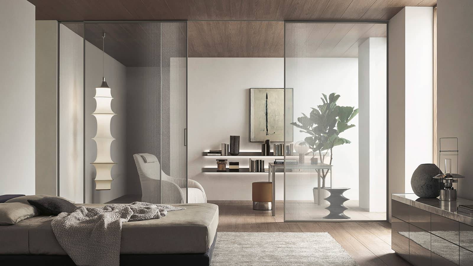 Rimadesio Velaria schuifdeur in rete glas met aluminium profiel, toegepast als transparante roomdivider tussen slaapruimte en werkruimte