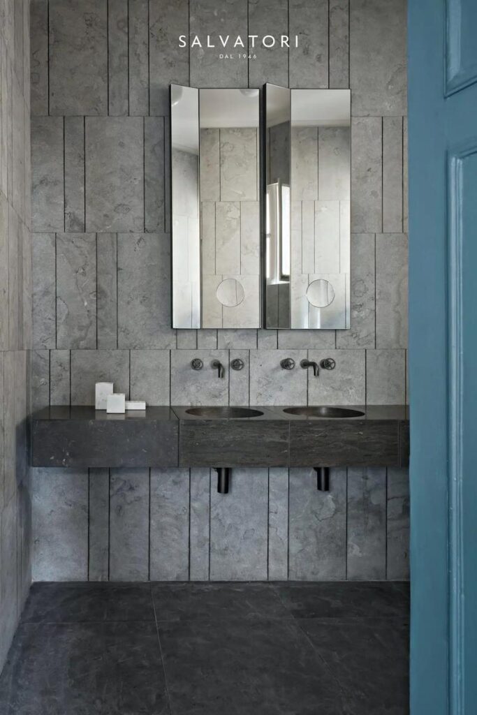 Luxe badkamer met verticale natuursteen wandpanelen en massieve wastafel van Salvatori.