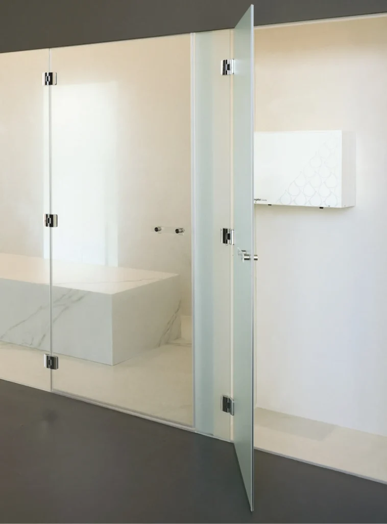 EFFE Nuvola Smart externe stoomgenerator zichtbaar naast een hammam ruimte met glazen deur en marmeren zitbank