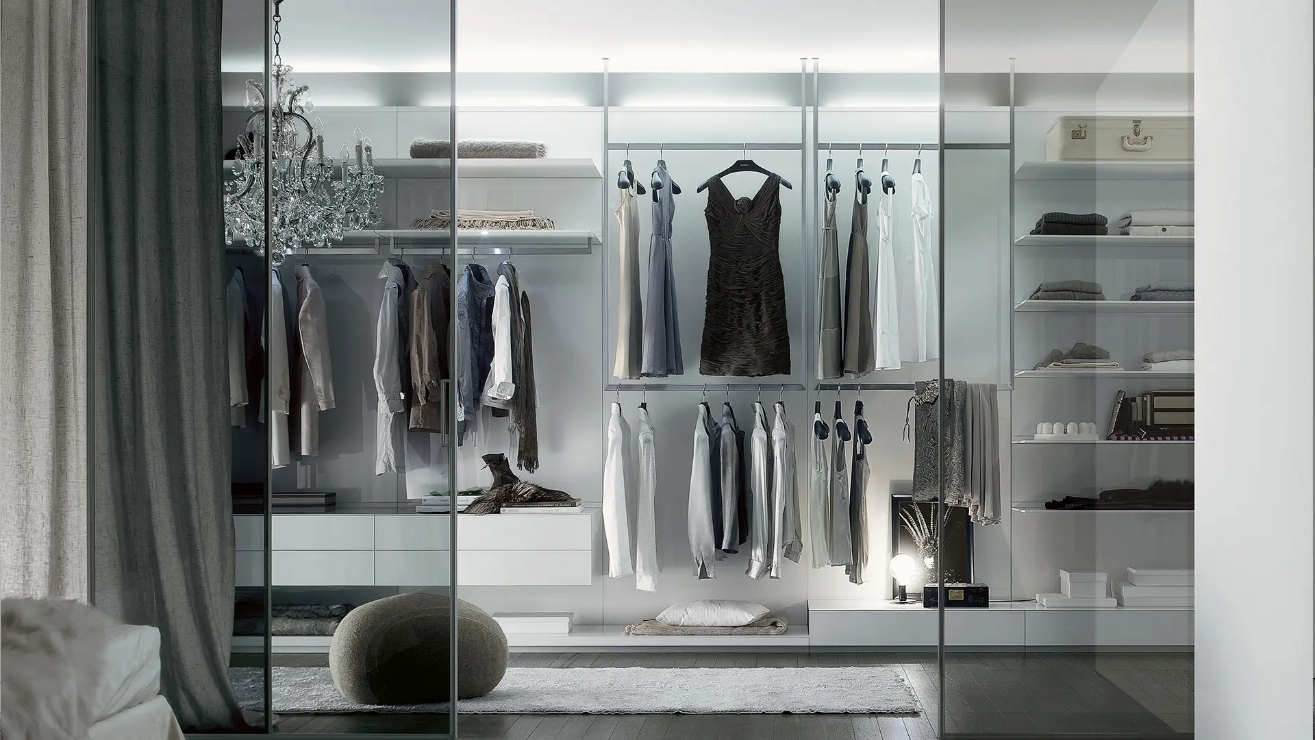 Open inloopkast met modulair garderobesysteem van Rimadesio Abacus achter glazen schuifpanelen, met zichtbare kleding, planken en lades geïntegreerd in een slaapkamer dressingruimte.