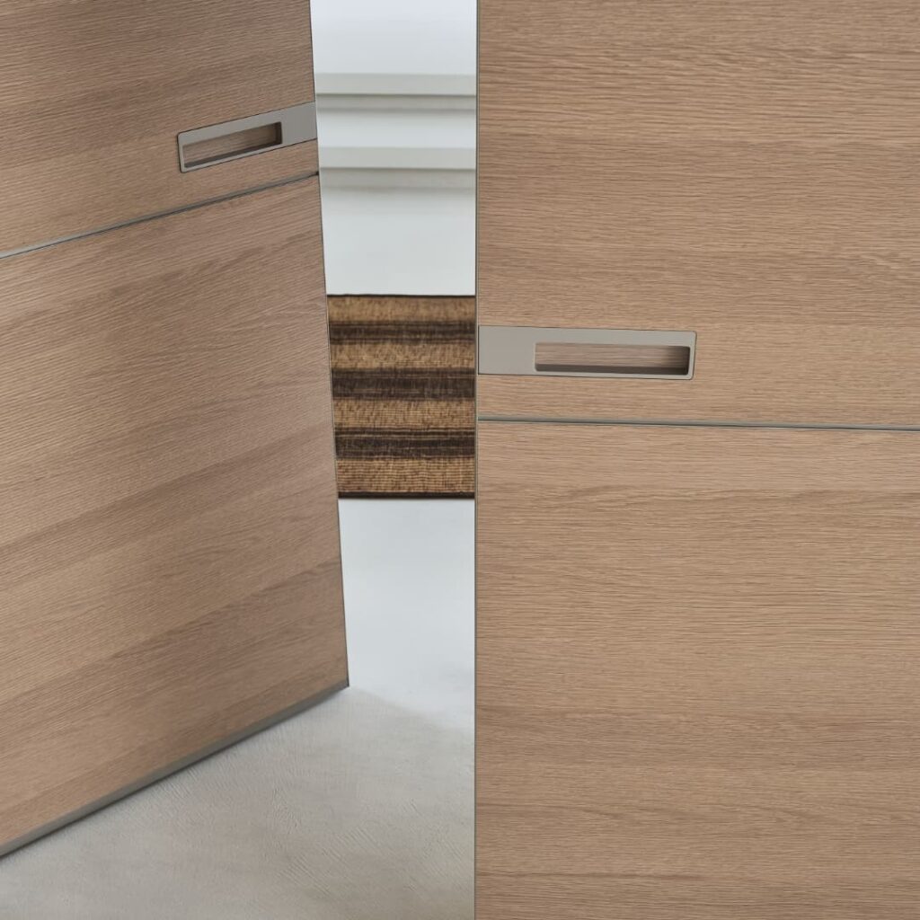 Detail van de geïntegreerde handgreep van een Rimadesio Radius taatsdeur in licht eikenhout met coplanaire wandintegratie