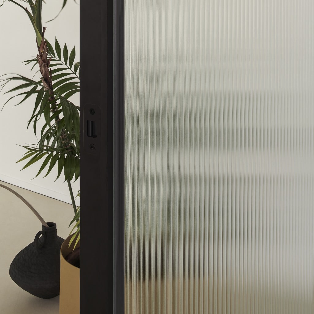 Detail van het aluminium profiel en geribbeld veiligheidsglas van de Glas Italia Aladin Wall Duo scheidingswand